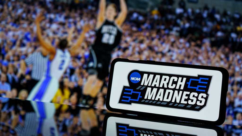 March Madness sign in front of basketball players