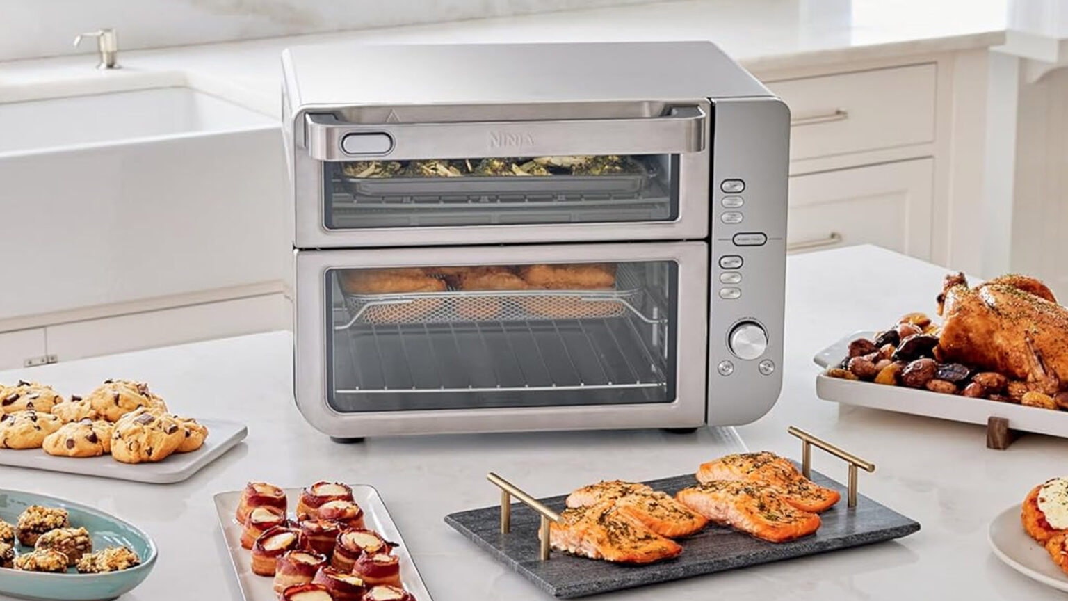 The air fryer oven on a counter, surrounded by dishes of food